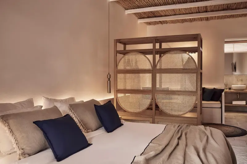 Une chambre à coucher lumineuse avec un grand lit et une décoration naturelle.