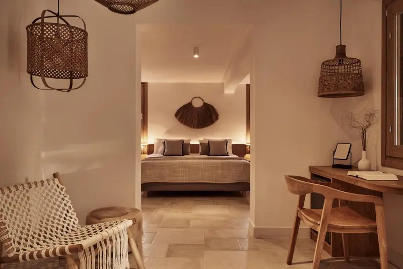 Une chambre lumineuse avec un lit fait et un espace bureau.