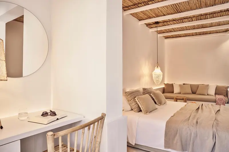 Une chambre lumineuse avec un lit confortable et un espace détente.