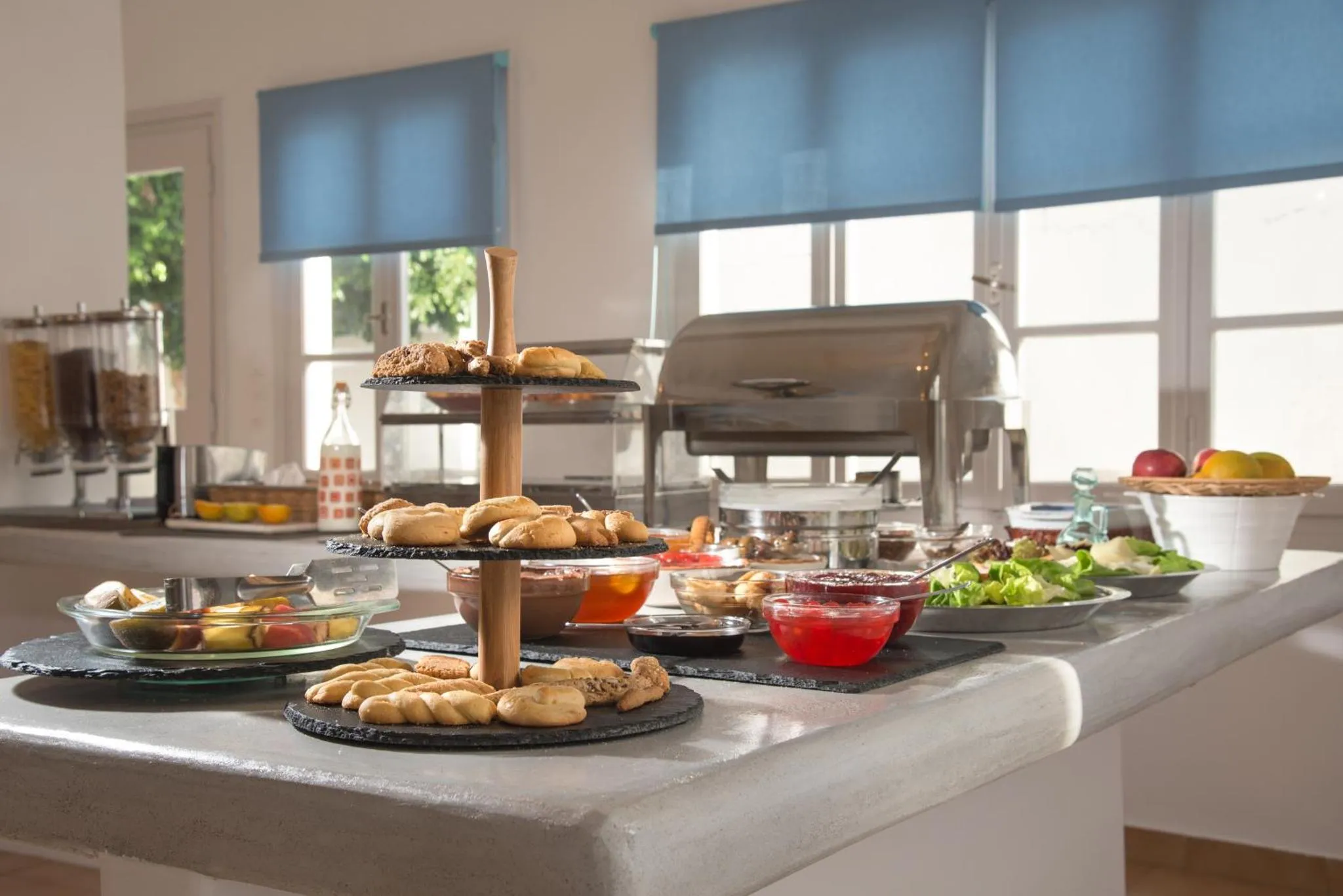 Un buffet propose des viennoiseries, des fruits et des salades.