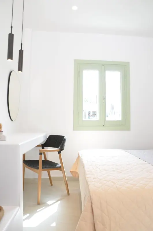 Une chambre lumineuse avec un bureau et un lit.