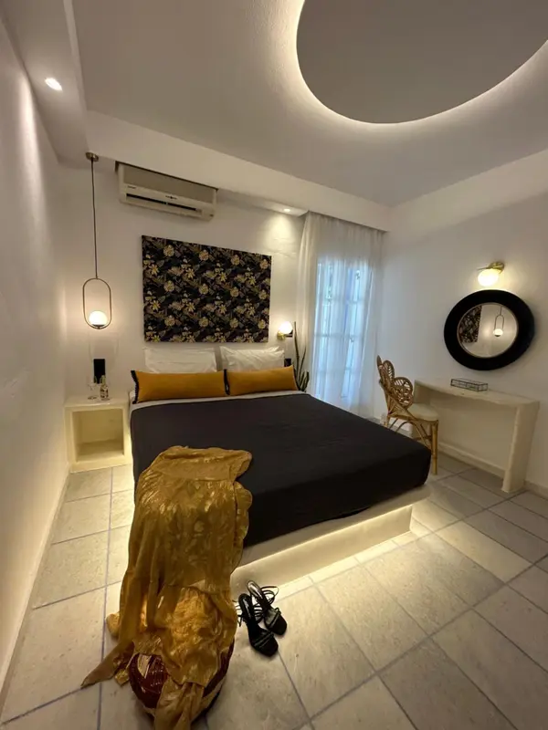 Une chambre lumineuse avec un grand lit recouvert d'une couverture dorée.