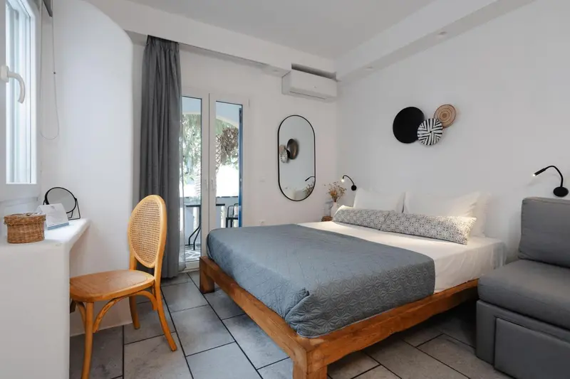Une chambre lumineuse avec un grand lit et un coin salon.