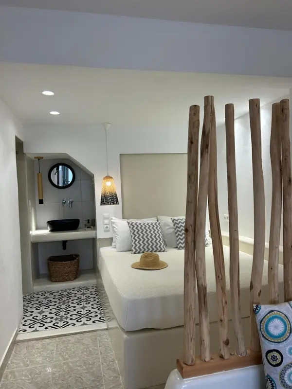 Une chambre lumineuse avec un lit et un espace lavabo.