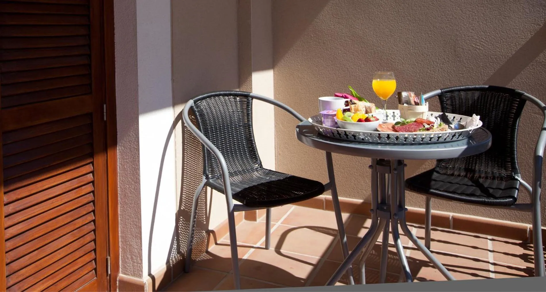 Une table servie pour le petit-déjeuner sur une terrasse ensoleillée.