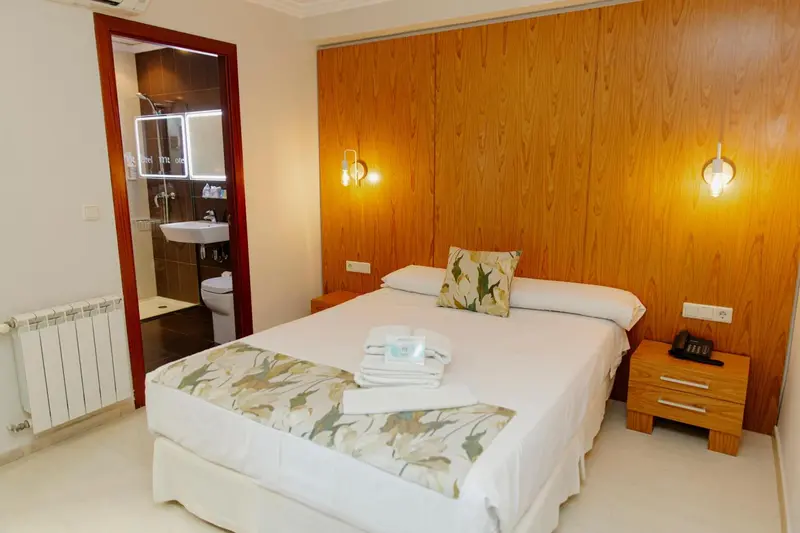 Une chambre lumineuse avec un lit et un accès à une salle de bain.