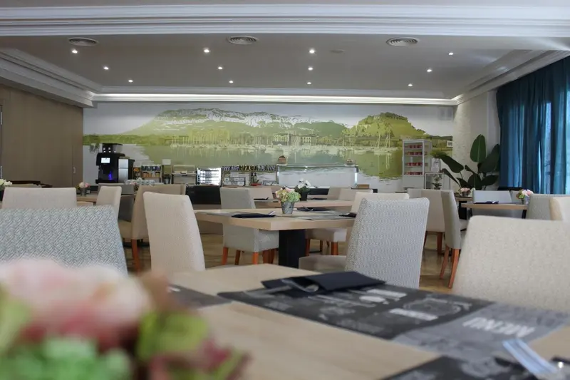 Une salle lumineuse avec des tables dressées pour le repas.