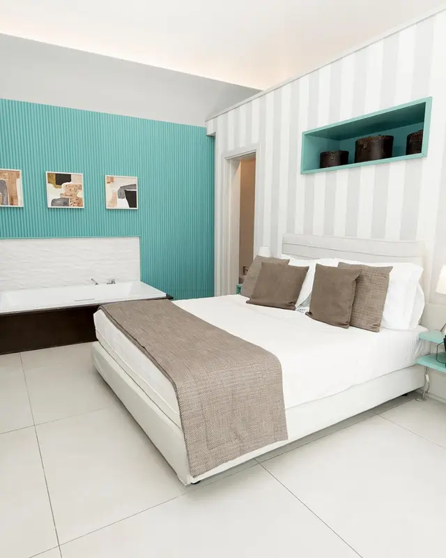 Une chambre lumineuse avec un grand lit et une baignoire.