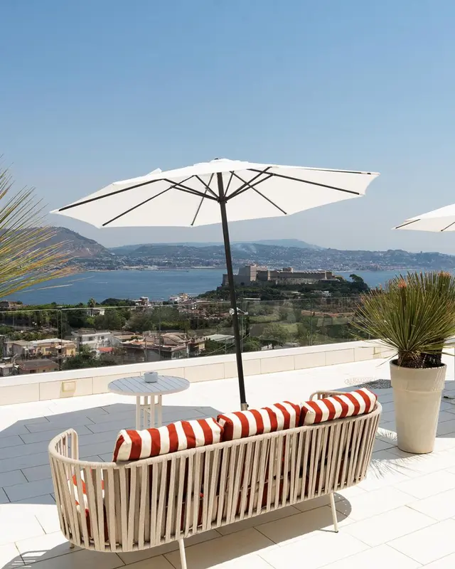 Vue d'une terrasse avec un canapé et une vue sur la mer.
