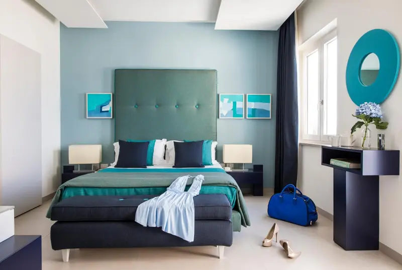 Une chambre moderne avec un grand lit et une décoration turquoise.