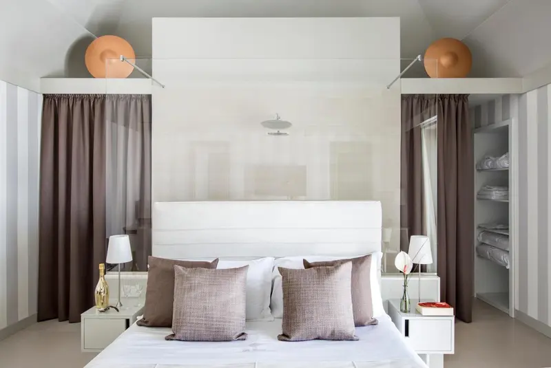 Lit double avec une moustiquaire blanche dans une chambre lumineuse.