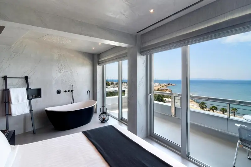 Une chambre moderne avec baignoire et vue sur la mer.