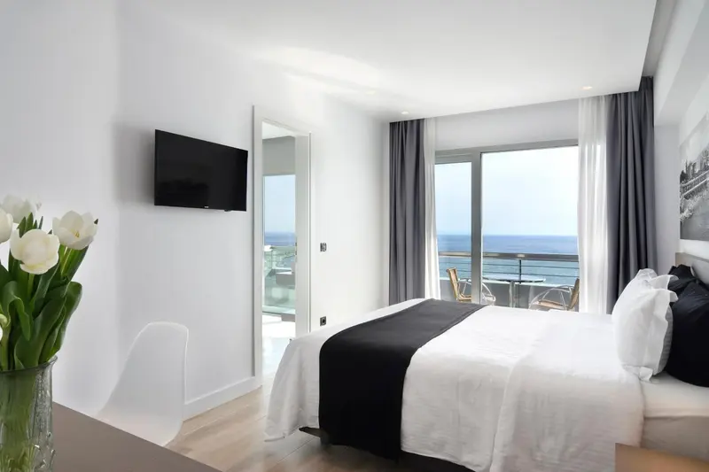 Une chambre lumineuse avec un grand lit et une vue sur la mer.