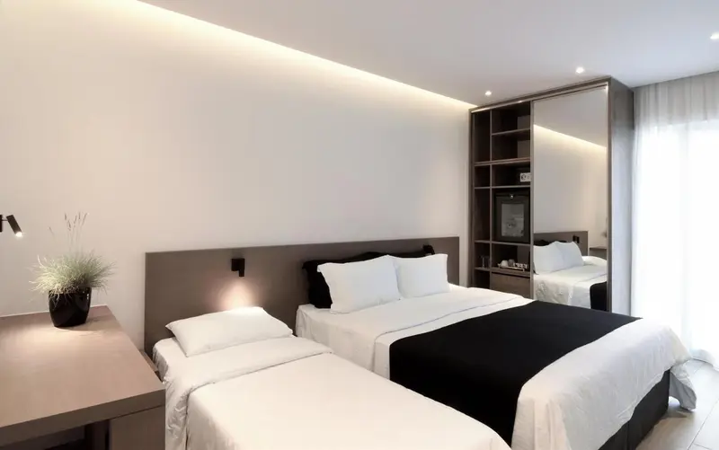 Une chambre moderne avec un grand lit et une décoration sobre.