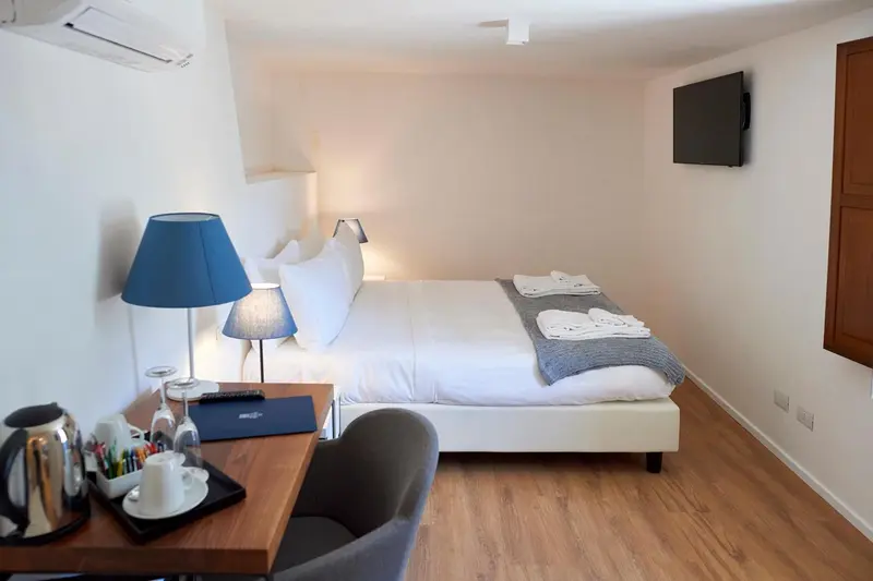 Une chambre lumineuse avec un lit double et une table de chevet.