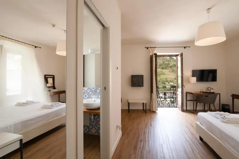 Chambre lumineuse avec lits simples et accès à une terrasse.