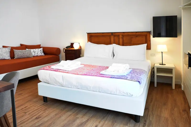 Une chambre lumineuse avec un grand lit et un canapé.