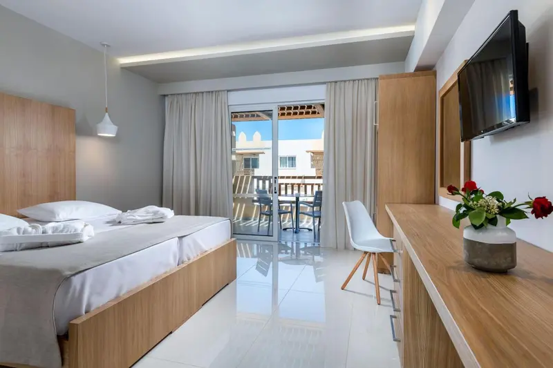 Une chambre lumineuse avec un lit double et un accès à une terrasse.