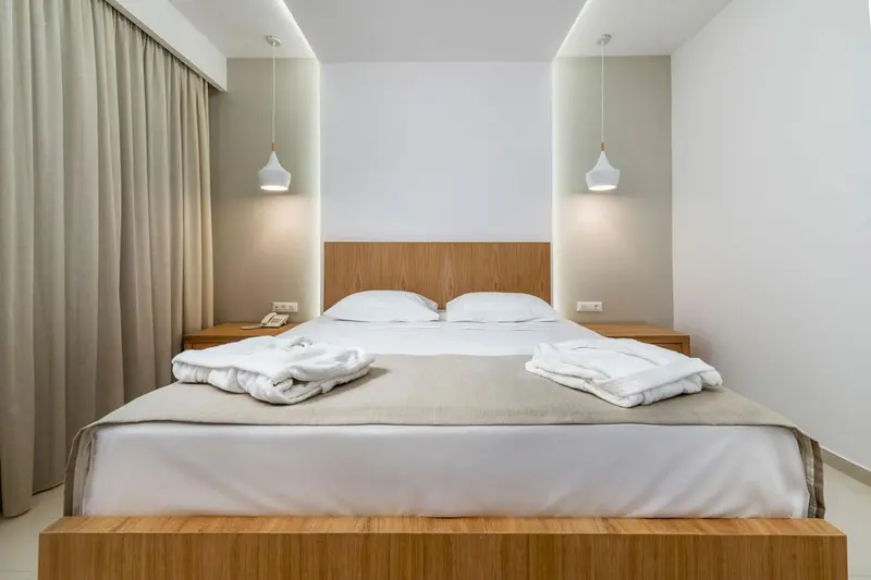Une chambre lumineuse avec un grand lit et une décoration sobre.