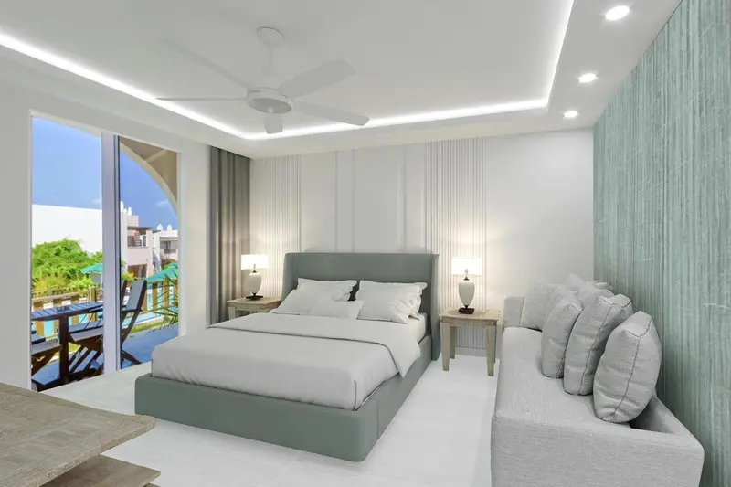 Chambre lumineuse avec un grand lit et un coin salon.