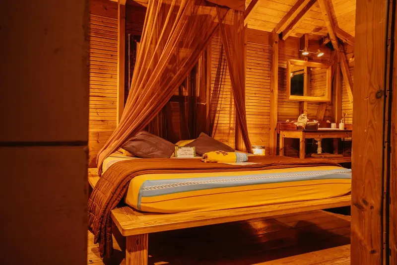 Une chambre à coucher chaleureuse avec un lit à baldaquin en bois.