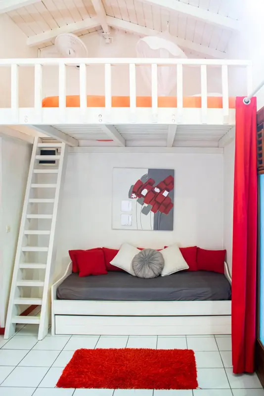 Une chambre avec un lit superposé et un canapé-lit.