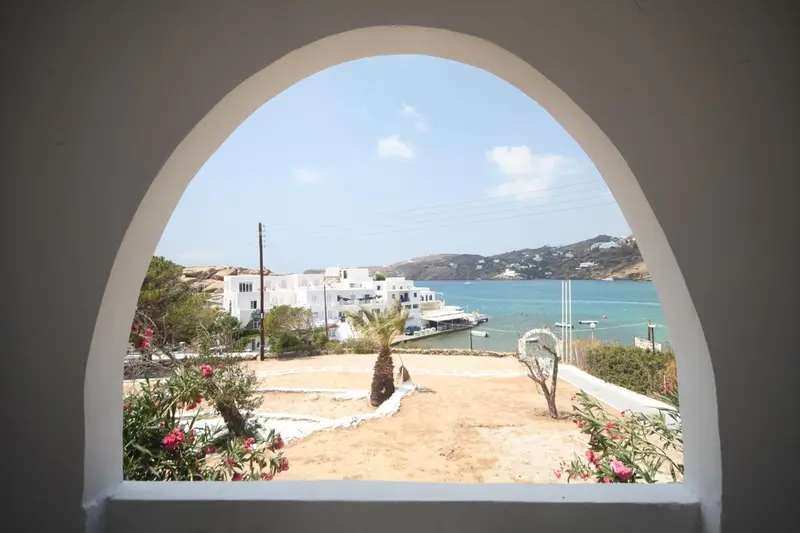 Vue sur un paysage côtier depuis une ouverture en arc.