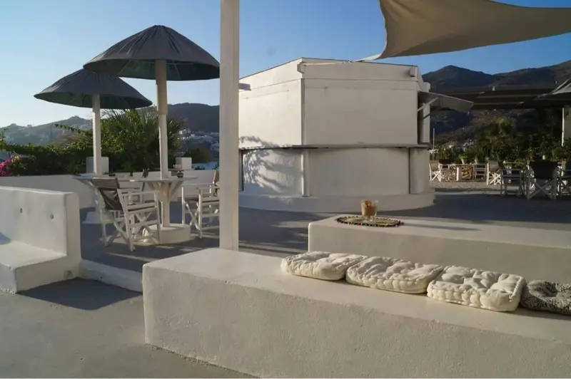 Terrasse aménagée avec assises et tables, vue sur les montagnes.