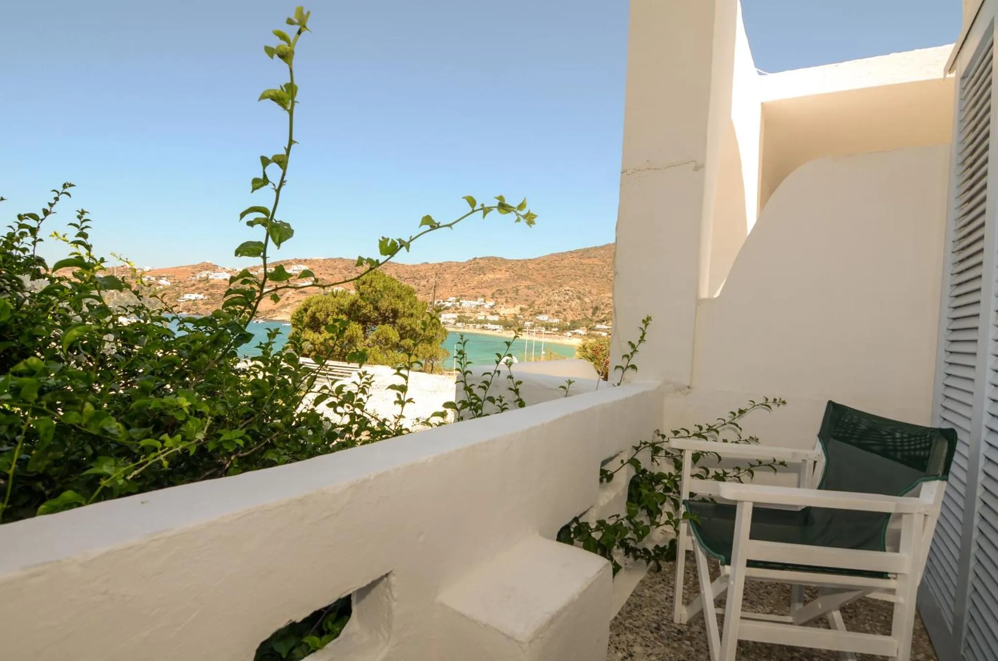 Une terrasse ensoleillée offre une vue sur la mer et les collines environnantes.