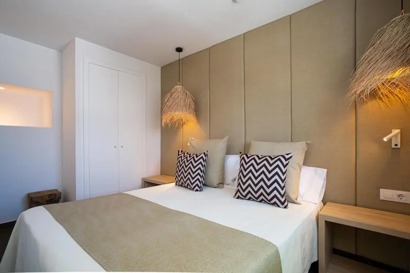 Une chambre lumineuse avec un grand lit et une décoration sobre.