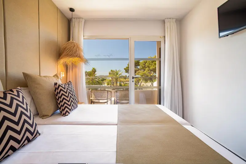 Une chambre lumineuse avec un grand lit et un accès à une terrasse.