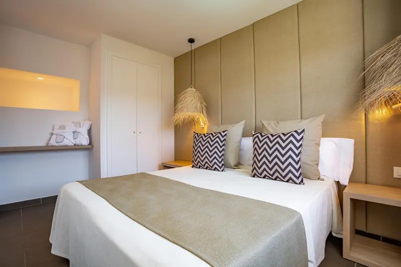 Une chambre lumineuse avec un grand lit et une décoration sobre.