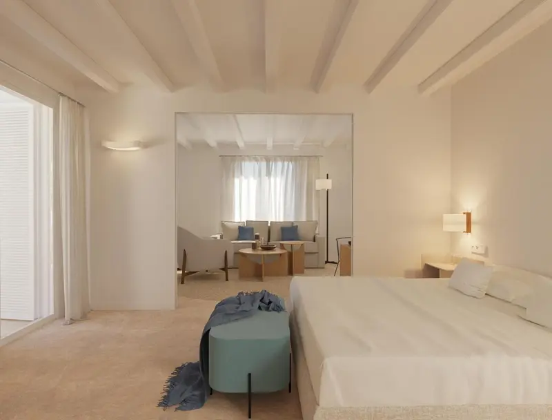 Une chambre lumineuse s'ouvre sur un espace de détente avec canapés.