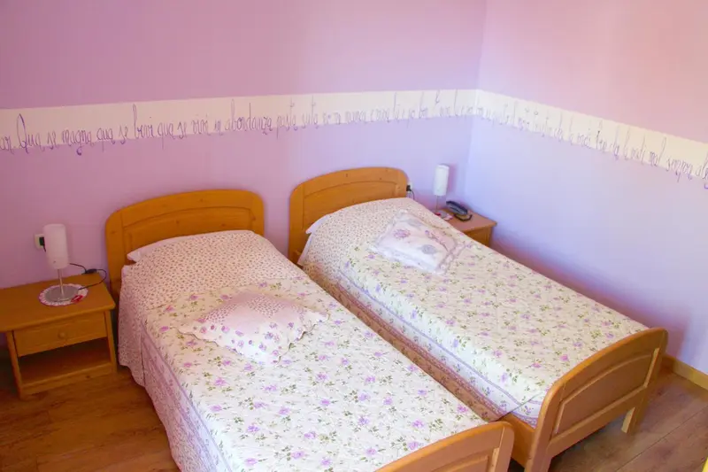 Une chambre avec deux lits simples et des tables de chevet.