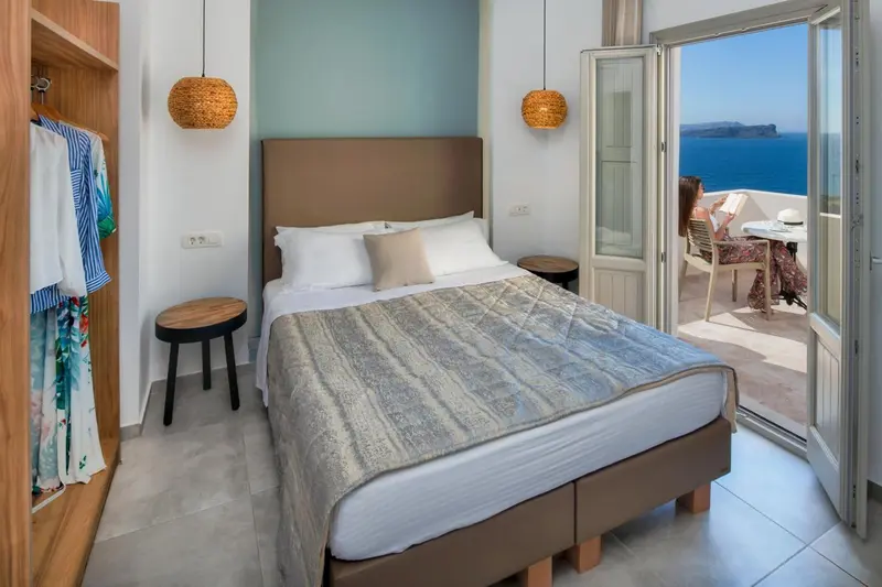Une chambre lumineuse s'ouvre sur une terrasse avec vue sur la mer.
