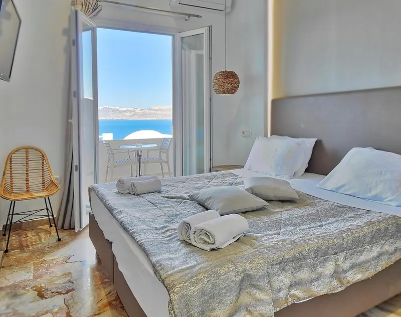 Une chambre lumineuse avec un grand lit et une vue sur la mer.