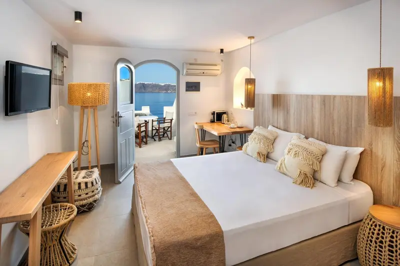 Chambre lumineuse avec un lit double et vue sur la mer.