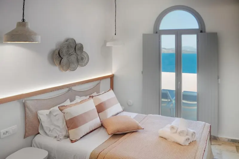 Une chambre lumineuse avec un grand lit et une vue sur la mer.