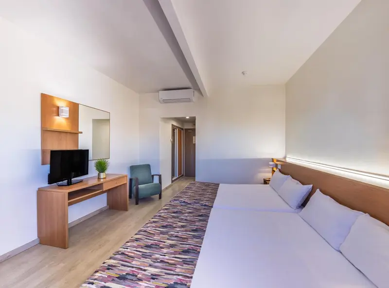 Une chambre lumineuse avec un lit et un espace détente.