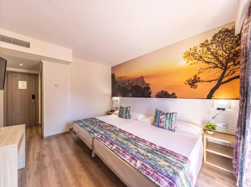 Une chambre lumineuse avec un grand lit et une décoration murale représentant un paysage.