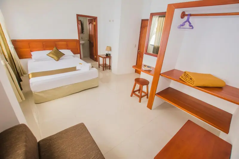 Une chambre lumineuse avec un lit double et un espace bureau.