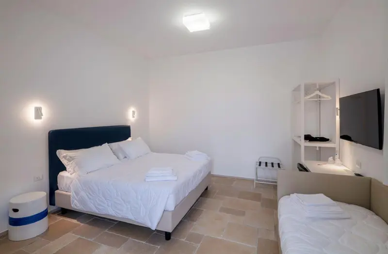Chambre lumineuse avec un grand lit et un espace détente.