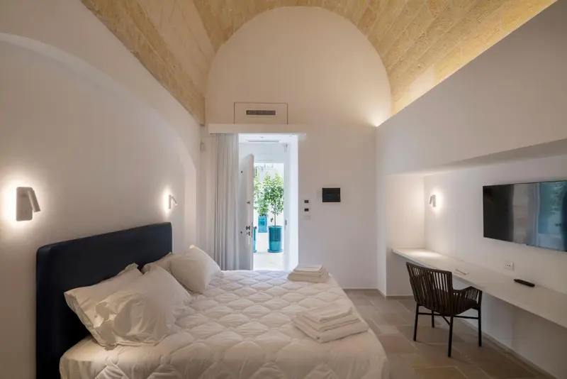 Une chambre lumineuse avec un grand lit et un espace bureau.