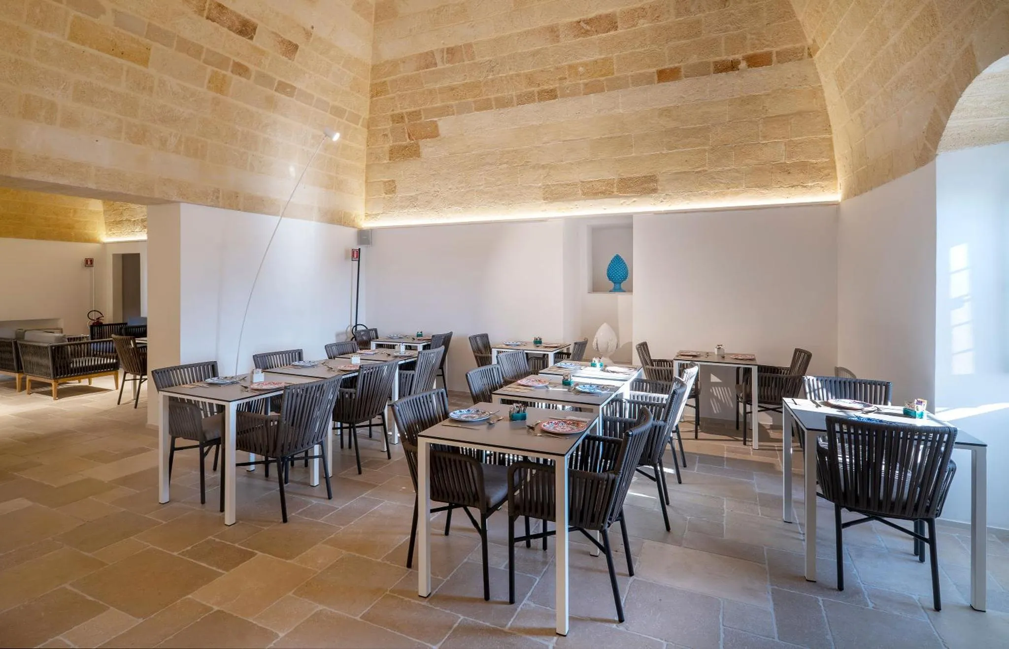 Une salle lumineuse avec des tables dressées pour un repas.