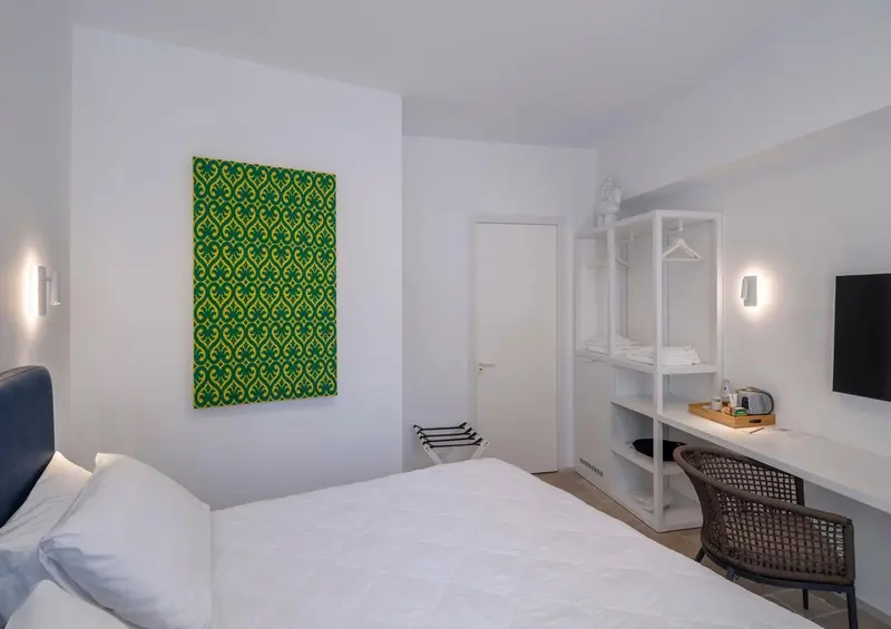 Une chambre lumineuse avec un grand lit et un bureau.