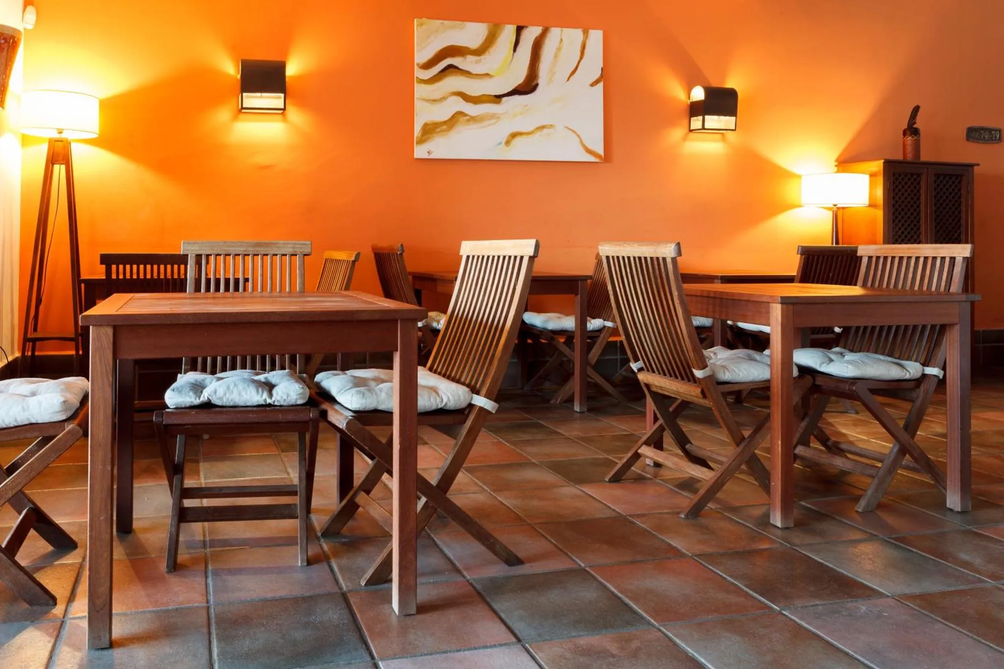 Une salle à manger avec des tables en bois et des chaises.