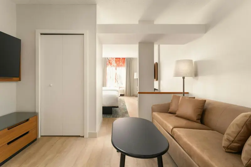 Espace de vie avec canapé et accès à une chambre.