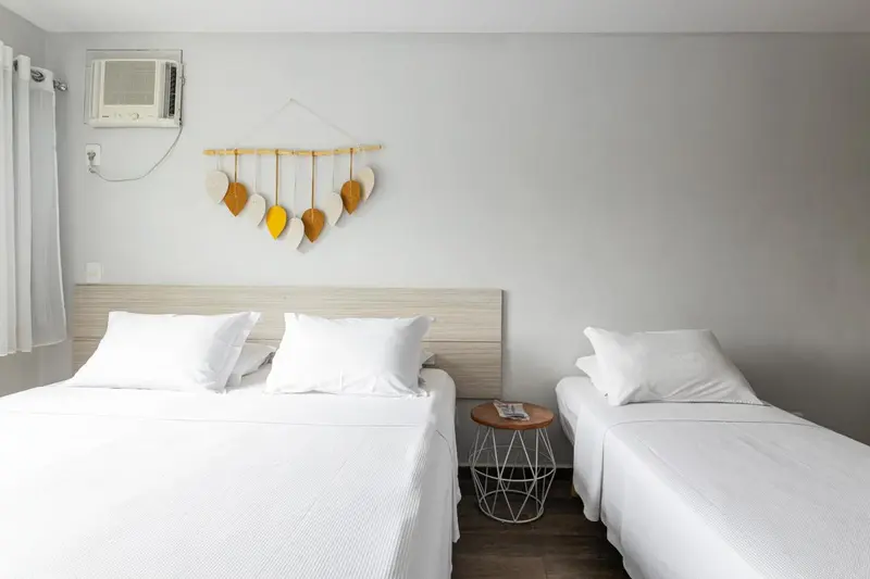 Une chambre lumineuse avec deux lits simples et une décoration murale.