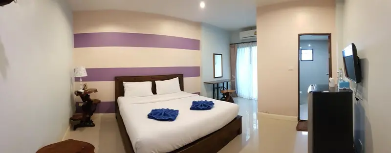 Une chambre lumineuse avec un grand lit et une décoration sobre.