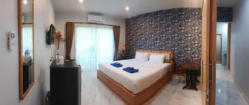 Une chambre lumineuse avec un grand lit et un accès à une terrasse.